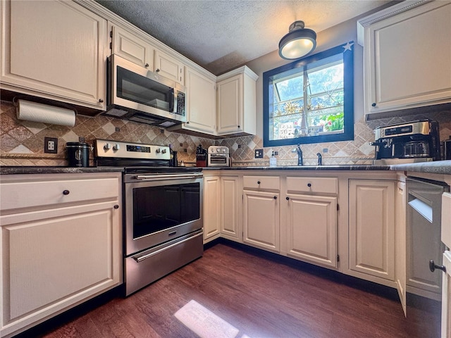 3664 SE 45th Pl, Ocala, FL 34480 - kitchen featuring appliances with stainless steel finishes, dark countertops, dark wood-style flooring, decorative backsplash, and a textured ceiling