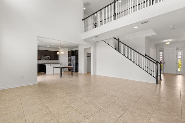 752 Sandy Bar Dr, Winter Garden, FL 34787 - unfurnished living room featuring light tile patterned floors, a high ceiling, stairs, a chandelier, and recessed lighting