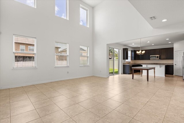 752 Sandy Bar Dr, Winter Garden, FL 34787 - unfurnished living room with light tile patterned flooring, a chandelier, a towering ceiling, and recessed lighting
