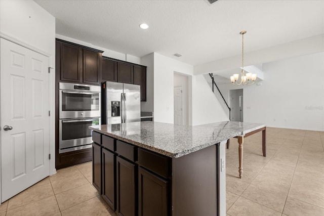 752 Sandy Bar Dr, Winter Garden, FL 34787 - kitchen featuring stainless steel appliances, light tile patterned floors, light stone counters, a chandelier, and dark brown cabinets