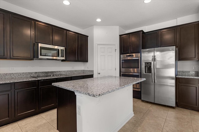 752 Sandy Bar Dr, Winter Garden, FL 34787 - kitchen featuring appliances with stainless steel finishes, light stone counters, light tile patterned floors, a kitchen island, and dark brown cabinets