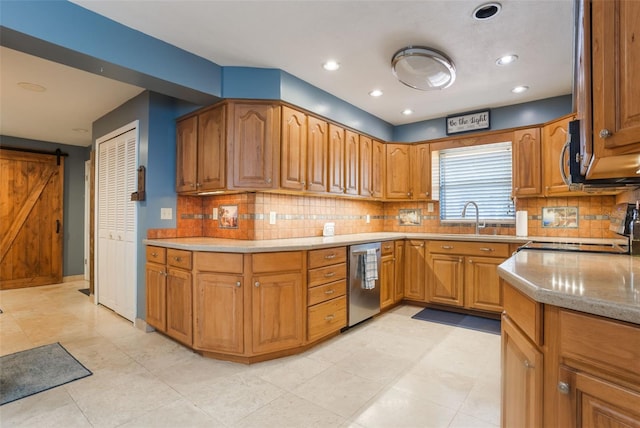 11750 Watts Ct, Tavares, FL 32778 - kitchen featuring stainless steel appliances, a barn door, backsplash, brown cabinets, and recessed lighting
