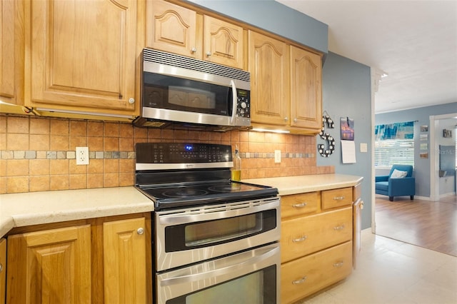 11750 Watts Ct, Tavares, FL 32778 - kitchen featuring stainless steel appliances, light countertops, light floors, and backsplash