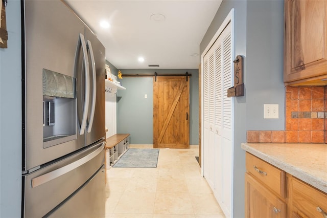 11750 Watts Ct, Tavares, FL 32778 - kitchen featuring stainless steel fridge, backsplash, light countertops, a barn door, and recessed lighting