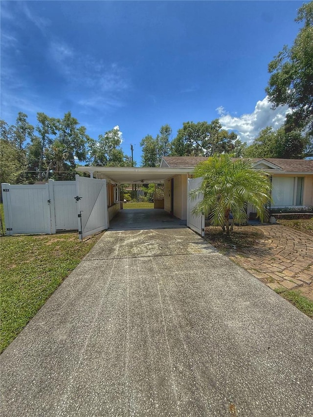 100 W Idlewild Ave, Eustis, FL 32726 - view of front of home with concrete driveway, a carport, and a gate