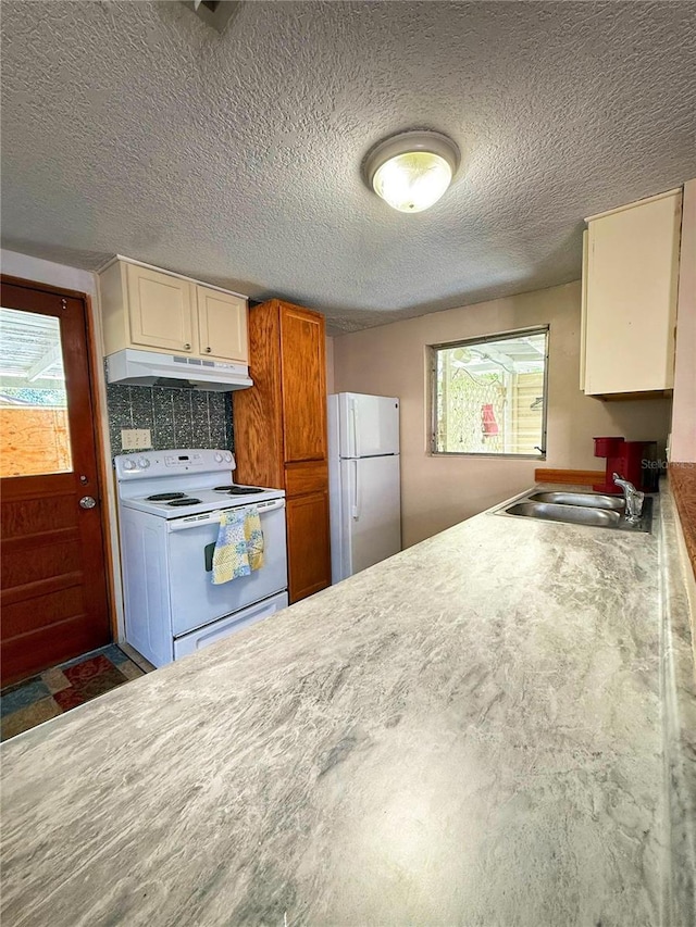 100 W Idlewild Ave, Eustis, FL 32726 - kitchen featuring white appliances, under cabinet range hood, a textured ceiling, and light countertops