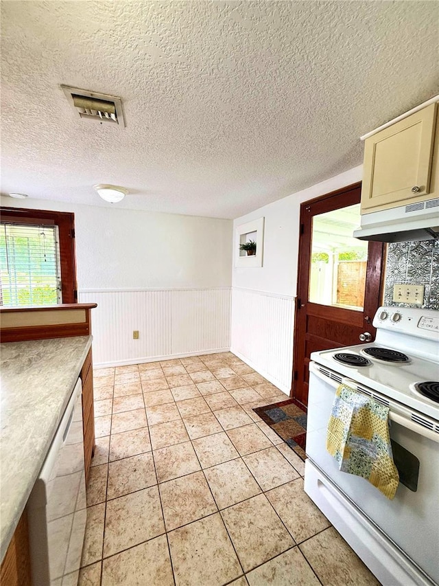 100 W Idlewild Ave, Eustis, FL 32726 - kitchen with white appliances, under cabinet range hood, wainscoting, plenty of natural light, and a textured ceiling