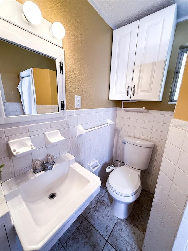 100 W Idlewild Ave, Eustis, FL 32726 - bathroom featuring tile walls, a textured ceiling, a wainscoted wall, and tile patterned flooring