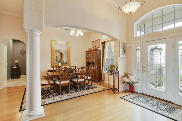 1426 Lakemist Ln, Clermont, FL 34711 - entryway with wood finished floors, crown molding, arched walkways, a chandelier, and decorative columns