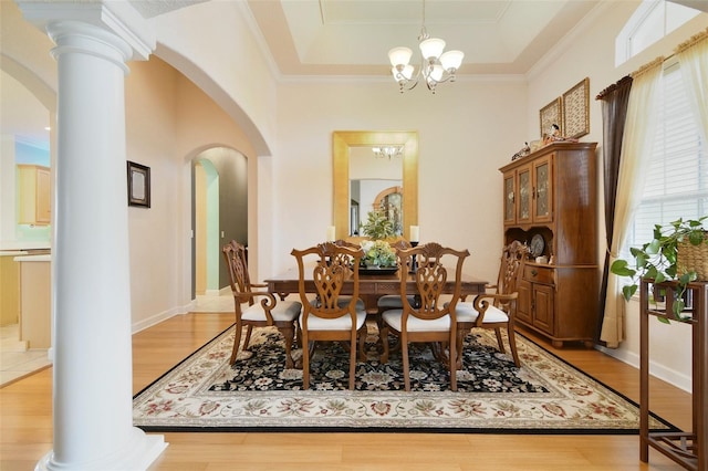 1426 Lakemist Ln, Clermont, FL 34711 - dining area featuring arched walkways, light wood-type flooring, a chandelier, crown molding, and a tray ceiling