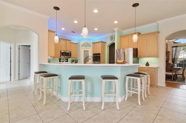 1426 Lakemist Ln, Clermont, FL 34711 - kitchen with appliances with stainless steel finishes, arched walkways, light brown cabinets, a peninsula, and crown molding