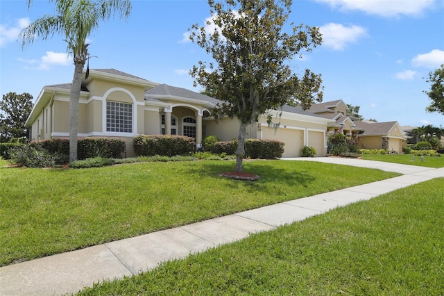 1426 Lakemist Ln, Clermont, FL 34711 - view of front of property featuring a garage, stucco siding, a front yard, and driveway
