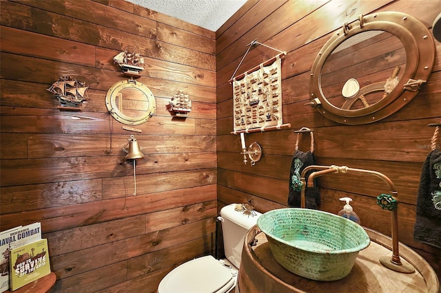 672 E Belt Ave, Bushnell, FL 33513 - half bath with wooden walls, toilet, and a textured ceiling