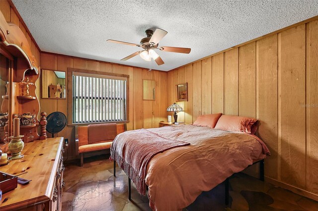 672 E Belt Ave, Bushnell, FL 33513 - bedroom featuring wooden walls, a textured ceiling, stone finish flooring, and a ceiling fan