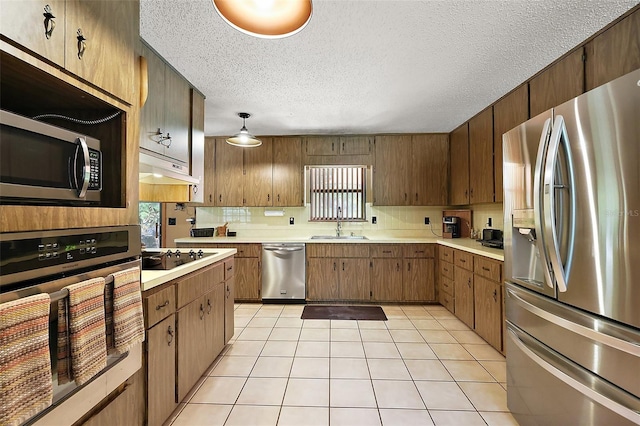 672 E Belt Ave, Bushnell, FL 33513 - kitchen with appliances with stainless steel finishes, light countertops, a textured ceiling, light tile patterned floors, and healthy amount of natural light
