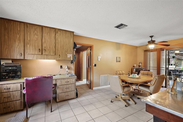 672 E Belt Ave, Bushnell, FL 33513 - kitchen featuring a desk, light countertops, a ceiling fan, a textured ceiling, and light tile patterned floors