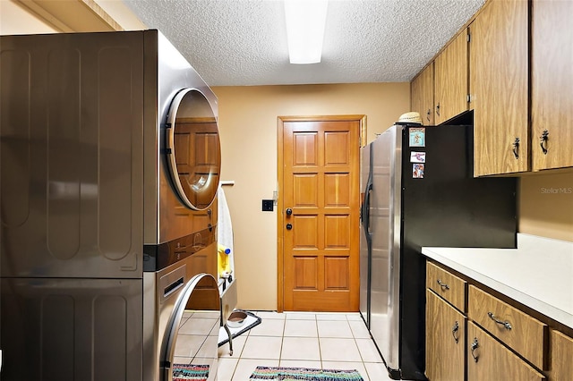672 E Belt Ave, Bushnell, FL 33513 - kitchen with estacked washer and dryer, freestanding refrigerator, a textured ceiling, light countertops, and light tile patterned floors