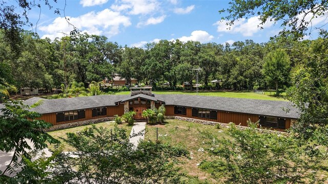 672 E Belt Ave, Bushnell, FL 33513 - view of front facade with driveway, view of scattered trees, and a front lawn