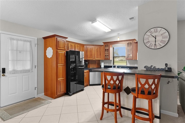 1815 Kaufman Cir, Lady Lake, FL 32159 - kitchen featuring black fridge, dishwasher, a peninsula, dark countertops, and brown cabinetry