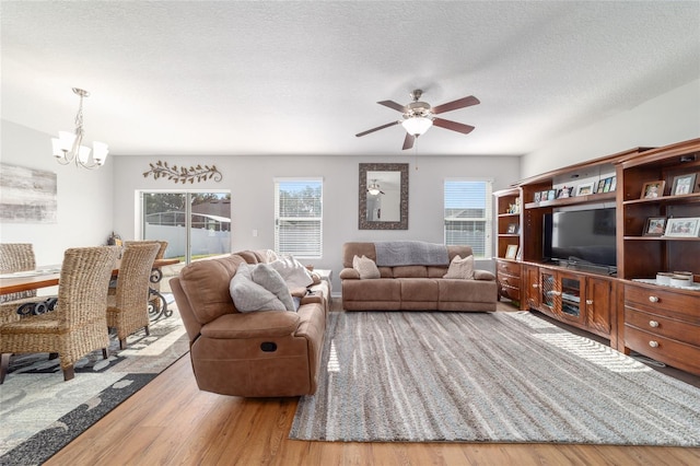 9785 Pepper Tree Trl, Wildwood, FL 34785 - living room with a chandelier, wood finished floors, a ceiling fan, and a textured ceiling