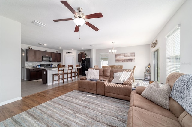 9785 Pepper Tree Trl, Wildwood, FL 34785 - living room with plenty of natural light, light wood finished floors, ceiling fan, a chandelier, and recessed lighting