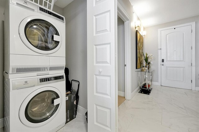 16300 County Road 455 Unit 202, Montverde, FL 34756 - laundry area with stacked washer / dryer, marble finish flooring, and baseboards