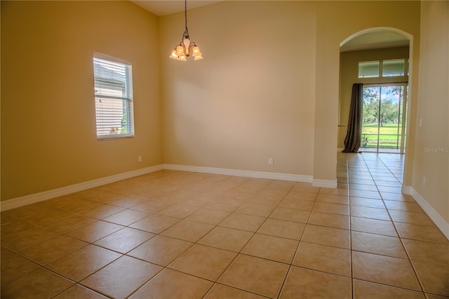 1355 Misty Glen Ln, Clermont, FL 34711 - spare room with arched walkways, light tile patterned flooring, and a chandelier