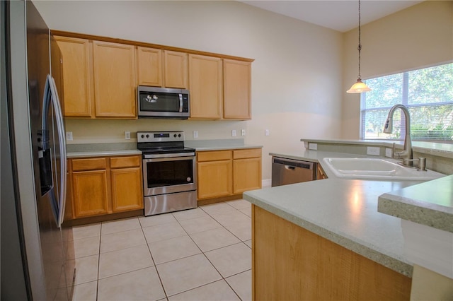1355 Misty Glen Ln, Clermont, FL 34711 - kitchen featuring appliances with stainless steel finishes, light countertops, light tile patterned floors, hanging light fixtures, and light brown cabinetry