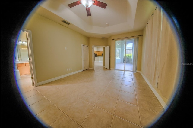 1355 Misty Glen Ln, Clermont, FL 34711 - spare room featuring a ceiling fan, light tile patterned floors, and a tray ceiling