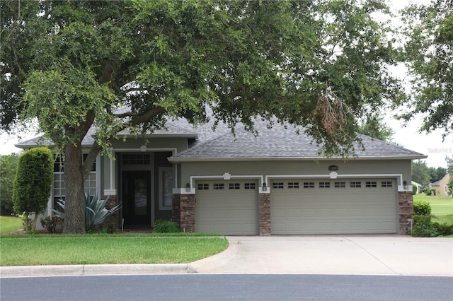 1355 Misty Glen Ln, Clermont, FL 34711 - view of front of property with an attached garage, stone siding, a shingled roof, driveway, and stucco siding