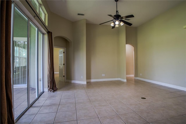 1355 Misty Glen Ln, Clermont, FL 34711 - unfurnished room with arched walkways, light tile patterned flooring, a ceiling fan, and a high ceiling
