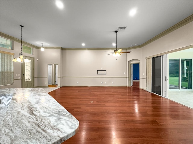 8045 Waterbury Way, Mount Dora, FL 32757 - unfurnished living room featuring ornamental molding, ceiling fan, wood finished floors, arched walkways, and recessed lighting