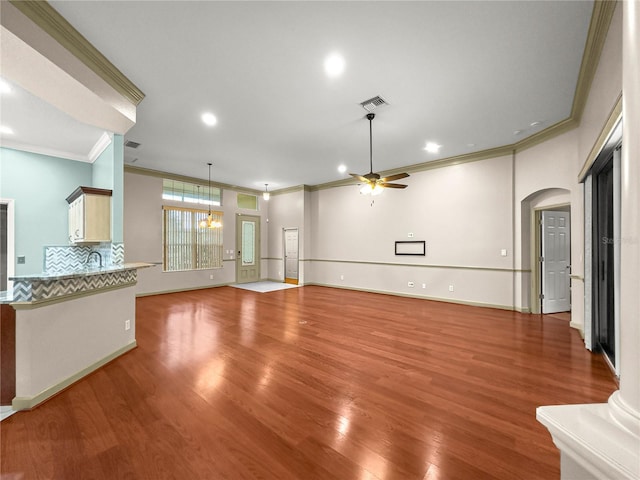 8045 Waterbury Way, Mount Dora, FL 32757 - unfurnished living room featuring ornamental molding, ceiling fan, light wood-type flooring, arched walkways, and recessed lighting