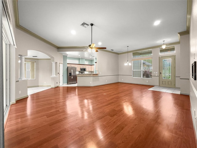 8045 Waterbury Way, Mount Dora, FL 32757 - unfurnished living room with ornamental molding, decorative columns, ceiling fan, arched walkways, and light wood-style floors