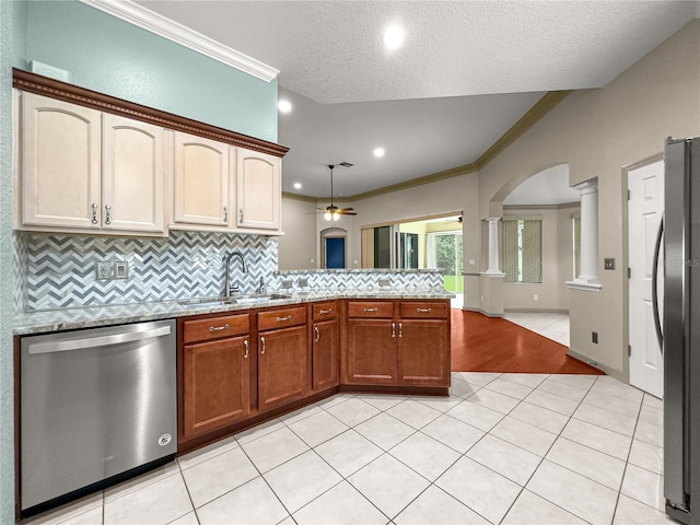 8045 Waterbury Way, Mount Dora, FL 32757 - kitchen with appliances with stainless steel finishes, decorative columns, crown molding, a peninsula, and tasteful backsplash