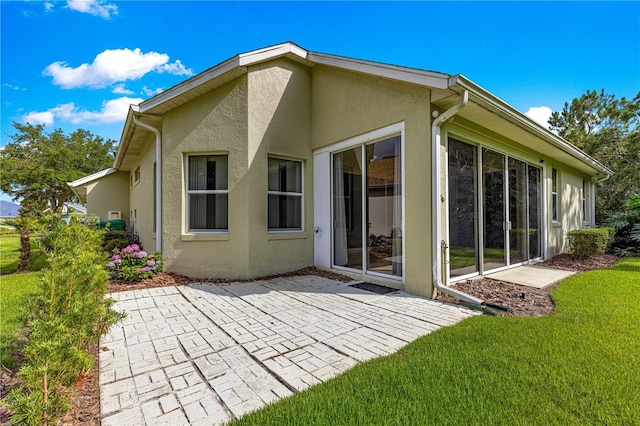 8045 Waterbury Way, Mount Dora, FL 32757 - back of house with a patio, stucco siding, and a yard
