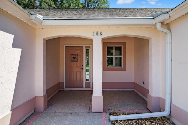 206 Palermo Pl, Lady Lake, FL 32159 - doorway to property featuring stucco siding and roof with shingles
