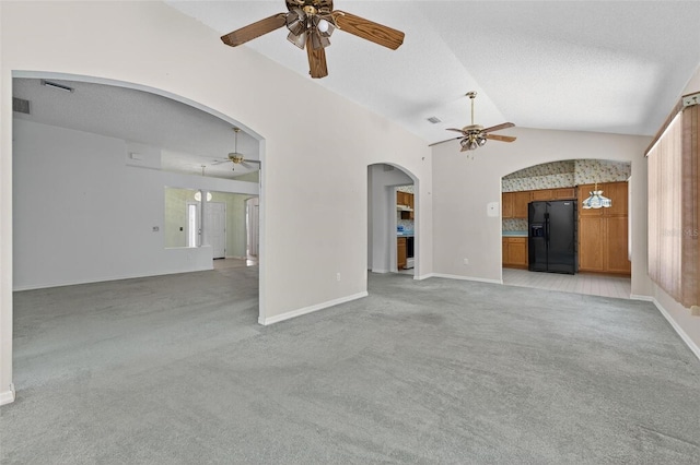206 Palermo Pl, Lady Lake, FL 32159 - unfurnished living room with a ceiling fan, arched walkways, light carpet, and lofted ceiling