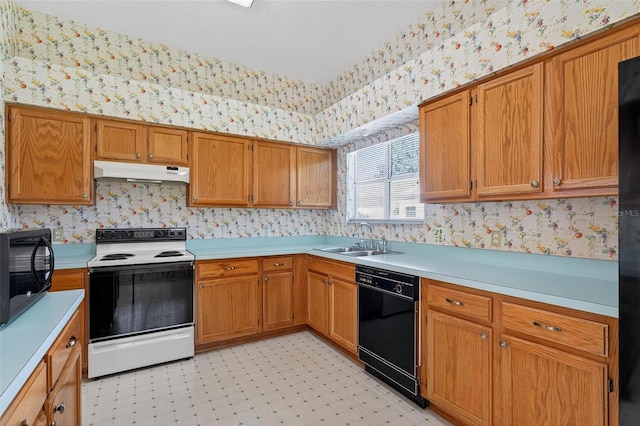206 Palermo Pl, Lady Lake, FL 32159 - kitchen featuring black appliances, wallpapered walls, under cabinet range hood, light countertops, and brown cabinetry