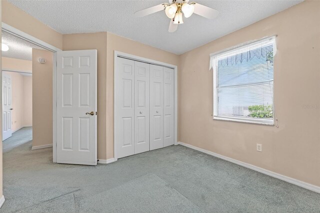 206 Palermo Pl, Lady Lake, FL 32159 - unfurnished bedroom with carpet, a closet, a textured ceiling, and a ceiling fan