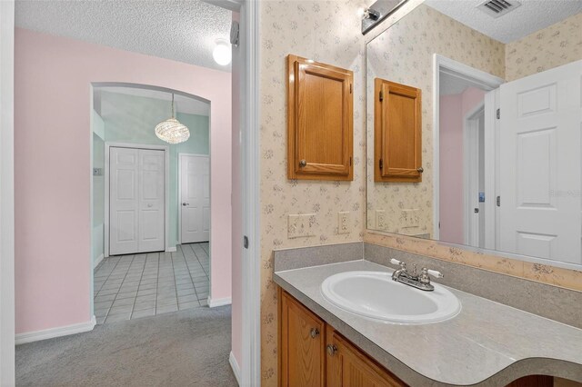 206 Palermo Pl, Lady Lake, FL 32159 - bathroom featuring wallpapered walls, a textured ceiling, vanity, and tile patterned floors