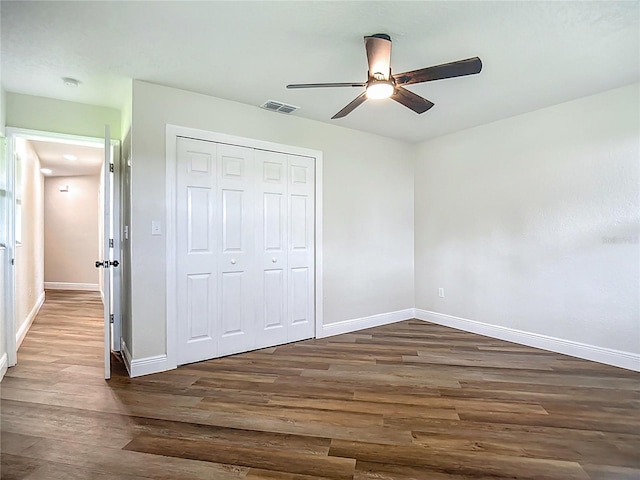 1611 Canal, Tavares, FL 32778 - unfurnished bedroom with dark wood-style flooring, a closet, and a ceiling fan