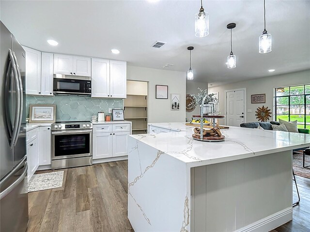 1611 Canal, Tavares, FL 32778 - kitchen with stainless steel appliances, dark wood-type flooring, a kitchen island, white cabinetry, and recessed lighting