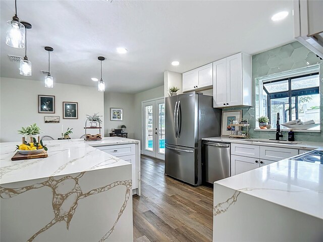 1611 Canal, Tavares, FL 32778 - kitchen featuring stainless steel appliances, dark wood finished floors, healthy amount of natural light, recessed lighting, and light stone counters