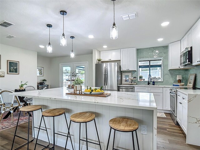 1611 Canal, Tavares, FL 32778 - kitchen featuring appliances with stainless steel finishes, backsplash, a kitchen breakfast bar, plenty of natural light, and recessed lighting