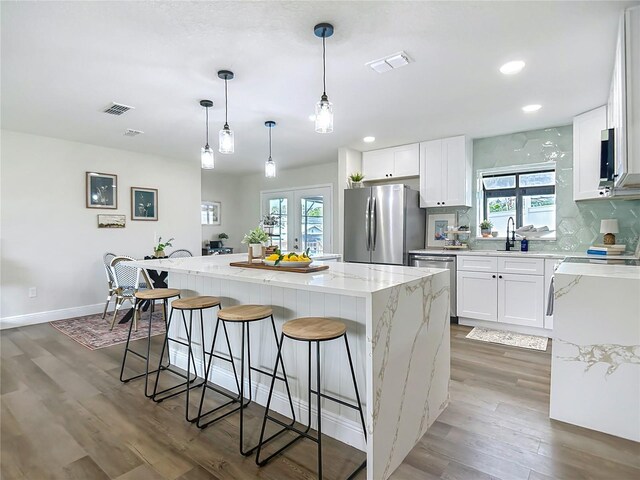 1611 Canal, Tavares, FL 32778 - kitchen featuring appliances with stainless steel finishes, a kitchen island, light wood-type flooring, healthy amount of natural light, and recessed lighting