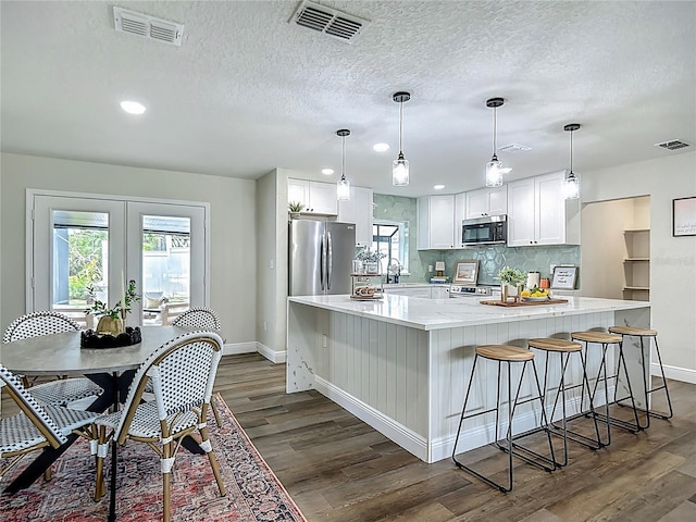 1611 Canal, Tavares, FL 32778 - kitchen with appliances with stainless steel finishes, dark wood-style floors, light countertops, white cabinetry, and recessed lighting
