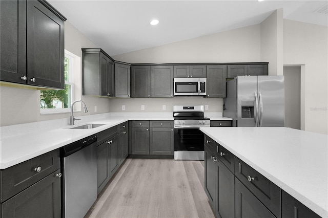 14631 SE 95th Ct, Summerfield, FL 34491 - kitchen with appliances with stainless steel finishes, vaulted ceiling, light wood-style floors, light countertops, and recessed lighting