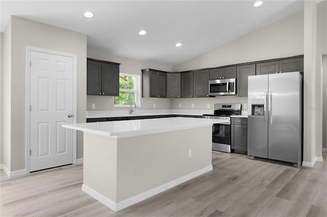 14631 SE 95th Ct, Summerfield, FL 34491 - kitchen with appliances with stainless steel finishes, a center island, light wood-style floors, light countertops, and lofted ceiling