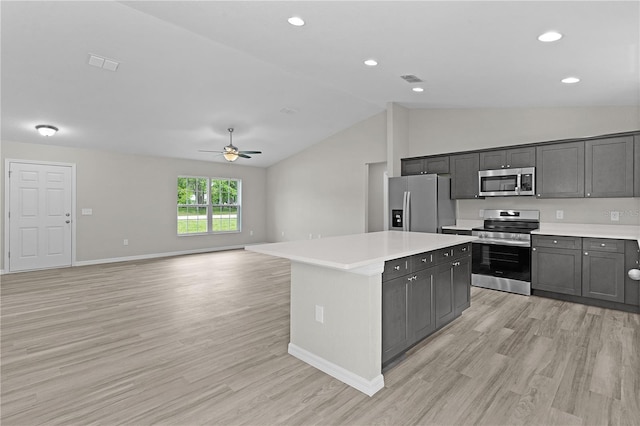 14611 SE 95th Ct, Summerfield, FL 34491 - kitchen featuring appliances with stainless steel finishes, a ceiling fan, lofted ceiling, light wood-type flooring, and a kitchen island